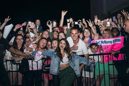 Selena Gomez trägt ihr sportliches Bustier zu High-Waist-Hose und Jeansjacke