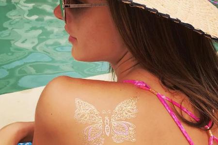 Alessandra Ambrosio schmückt sonnengeküsste Haut mit einem zarten Metallic-Tattoo