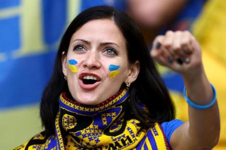 Mit Fanschal und Landesflagge im Gesicht feuert diese Ukraine-Anhängerin ihre Mannschaft im Spiel gegen Deutschland an.