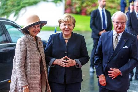 Gut gelaunt im Regen: Angela Merkel, Königin Silvia (li.) und Carl Gustaf beim gemeinsamen Treffen in Bundeskanzleramt