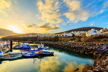 Malerische Sonnenuntergänge, wie hier über dem Hafen der Ortschaft Gran Tarajal, sind auf den Kanarischen Inseln keine Selte...