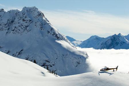 Ein Helikopter wartet vor einer Traumkulisse auf die Tiefschneefreaks