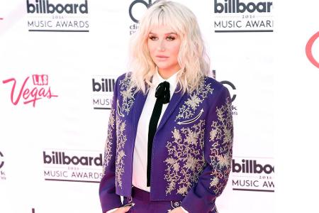 Kesha im pailettenverzierten lila Blazer
