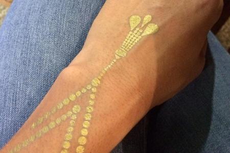 Goldenes Highlight: Moderatorin und Model Rebecca Mir setzt ihren Handrücken mit diesem glitzernden Flash-Tattoo in Szene.