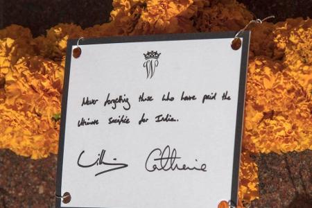 An dem Kranz, den William und Kate niederlegten, ist ein Schild mit dem royalen Emblem und einem Spruch (