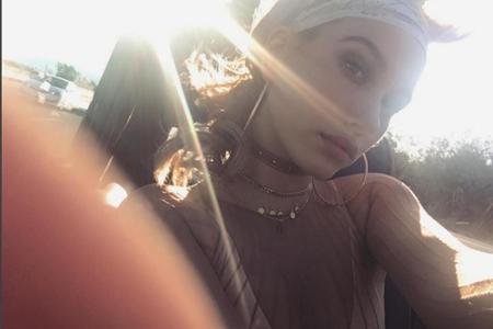 Auch sie trägt Choker und schützt sich mithilfe eines stylischen Haartuchs vor der Sonne.