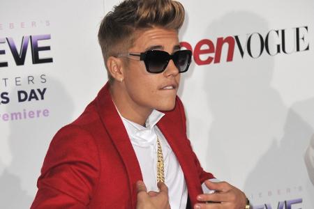 2013: Justin Bieber mit einem Ansatz von Oberlippenbart, Goldkette und rotem Jackett. Nur die Frisur bleibt erst mal...