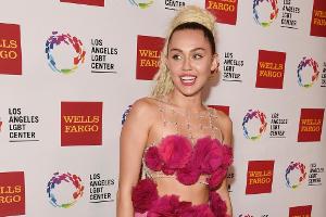 Miley Cyrus leckt an weißem Konzertflügel