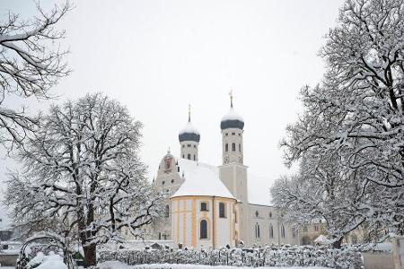 Die Klosterkirche in Benediktbeuern umgeben von einer malerischen Winterlandschaft