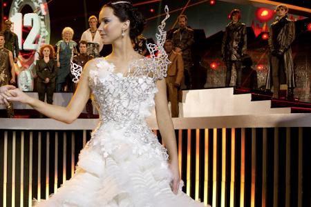 Auch das kitschige Hochzeitskleid, welches ihr von Snow aufgezwungen wird, verwandelt sich dank Cinna in ein Zeichen der Rev...