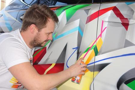 Graffiti-Künstler René Turrek bei der Sprüharbeit am Lexus NX