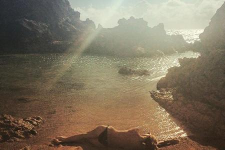 Model Heidi Klum rekelt sich oben ohne am Strand