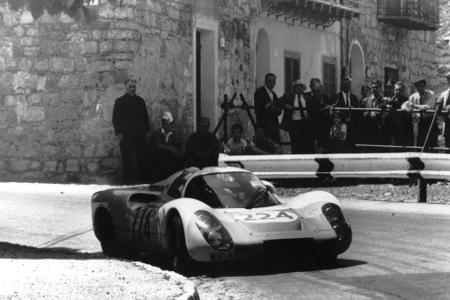 Ein Porsche 910/8 anno 1968 im Rennen unterwegs durch sizilianische Dörfer
