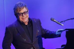 Elton John kippt mit seinem Stuhl um