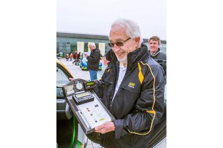 Fahrerverbindungsmann Jürgen Illig zeigt ein Rallye-Brett mit Stoppuhren und Roadbook.