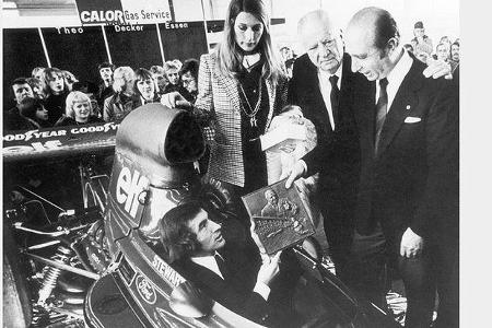 Der fünfmalige Formel 1-Weltmeister Juan Manuel Fangio (rechts) überreicht dem aktuellen Weltmeister Jackie Stewart die Alfr...