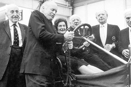 Der fünfmalige Formel 1-Weltmeister Juan Manuel Fangio (rechts) überreicht dem aktuellen Weltmeister Jackie Stewart die Alfr...