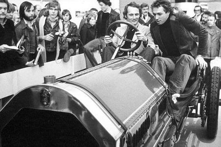 Formel 1-Weltmeister Niki Lauda (links) und Formel 1-Ass Jochen Mass zu zweit in einem uralten Monoposto.