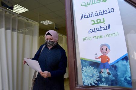Dame mit Kopftuch und Maske in einem Impfzentrum in Jerusalem