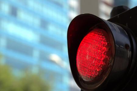 Vorausschauend fahren: Wenn man schon die rote Ampel in der Ferne erblickt, lohnt es sich nicht mehr, Gas zu geben. Lassen S...