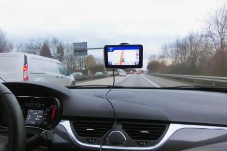 Wer kein eingebautes Navigationssystem im Auto hat, bedient sich eines portablen Navis und befestigt ihn mittig an der Front...