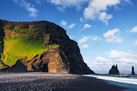 Tiefes Schwarz statt strahlendem Weiß dominiert den Strand von Reynisfjara auf Island. Erodiertes vulkanischen Gestein sorgt...