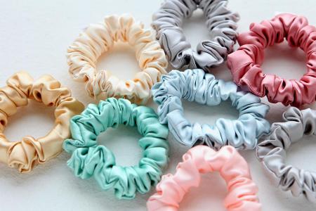 Ein essenzieller Teil des 90s-Looks: Scrunchies. Ob Zopf, Dutt oder Half-up-half-down - die großen Haargummis aus Stoff sind...