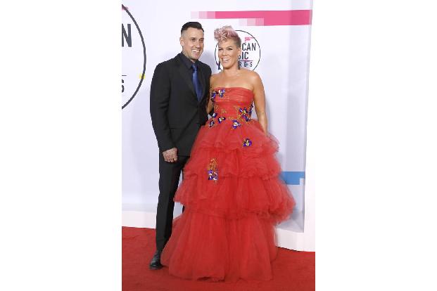 Pink war diejenige, die bei einem Motorradrennen von Carey Hart ein Schild hochhielt 