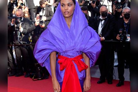 Deutlich bedeckter ging es bei Model Tina Kunakey zu. Sie wählte ein lilafarbenes Ensemble, das entfernt an Grace Jones erin...