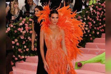 Kendall Jenner entschied sich für eine orangefarbene Robe mit Federoptik von Versace. Das enganliegende Kleid brachte ihre F...