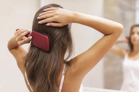 Für den Anfang geeignet ist eine Paddle Brush. Beim Kämmen stets Strähne für Strähne festhalten, so reißen die Haare bei Kno...