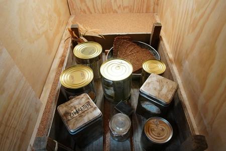 Durch eine Schleuse bekommen die Bewohner ihr Essen. Die Konserven erinnern an die kargen Mahlzeiten im Dschungel.