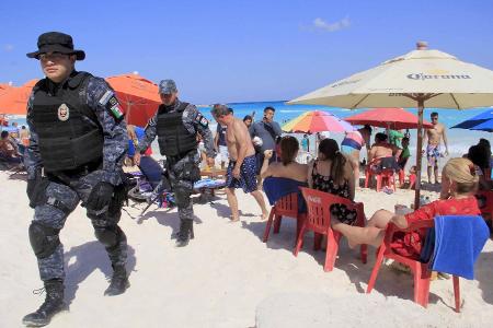 Mexican Police agents patrol amongs the tourists at a beach ...