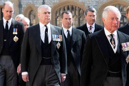 Prinz William (l.) und Prinz Charles (r.) distanzieren sich von Prinz Andrew (M.).