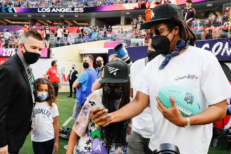 Rapper und Musikproduzent Jay-Z zeigt seiner Tochter Blue Ivy Carter ein Foto auf dem Smartphone.