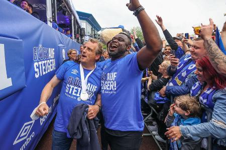 Interimstrainer Mike Büskens feiert mit Gerald Asamoah.
