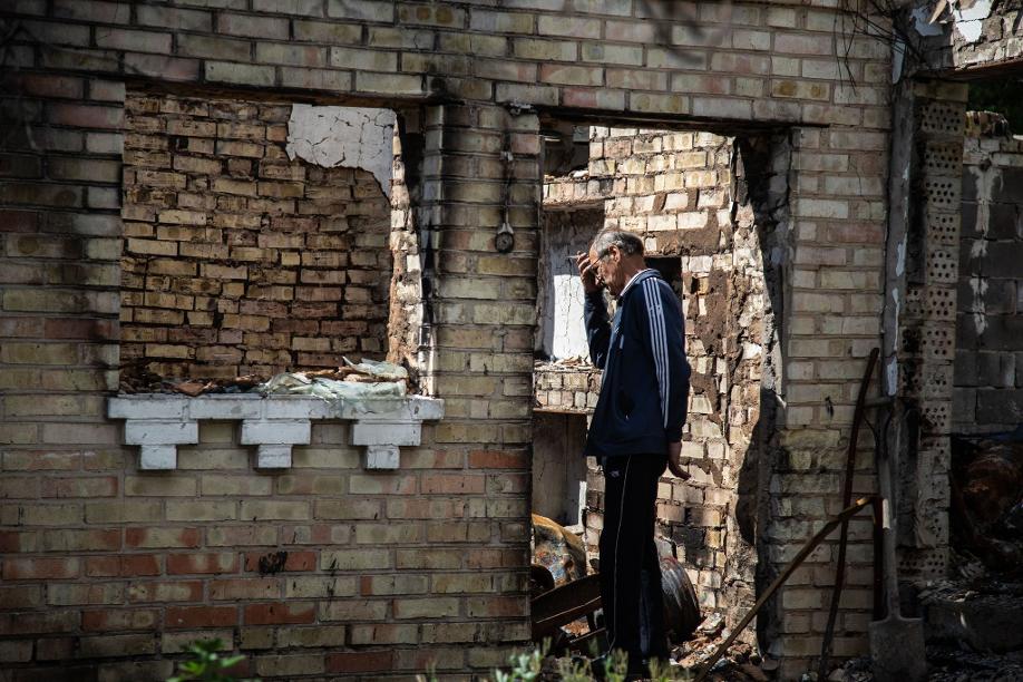 Ein Mann in Horenka steht in einem zerstörten Wohnhaus.