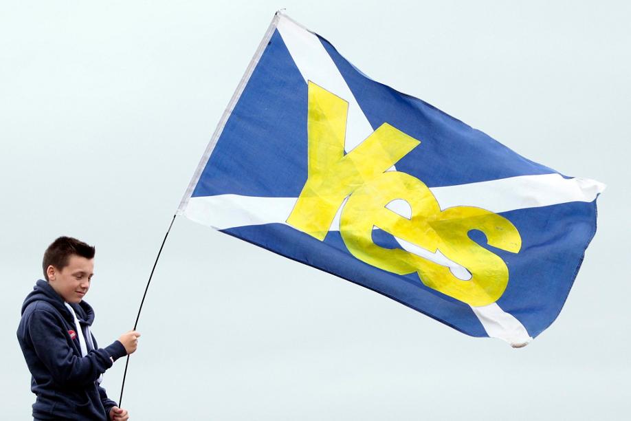 Ein Junge hält eine schottische Flagge mit der Aufschrift 
