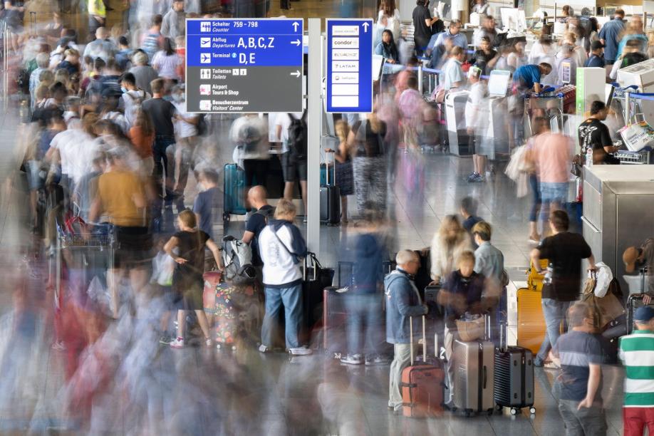 Passagiere warten vor den Abfertigungsschaltern des Frankfurter Flughafens auf ihren Check-in.