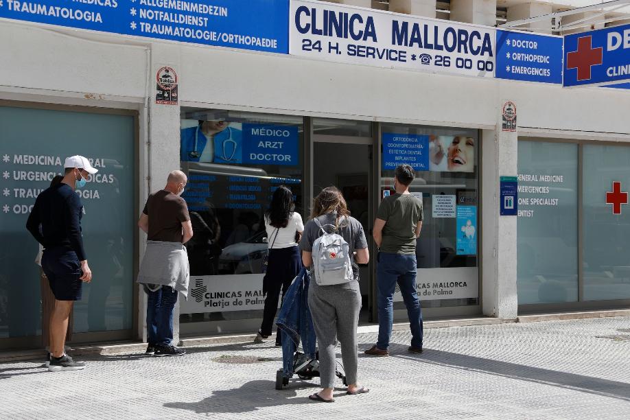 Menschen warten vor einem Covid-19-Testzentrum am Strand von El Arenal auf Mallorca.