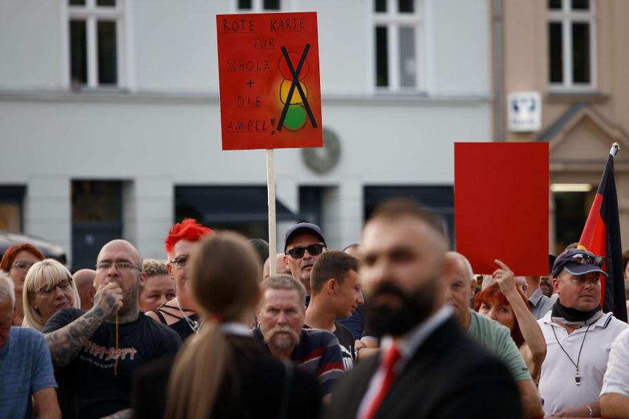 Zuschauer protestieren während der Rede von Bundeskanzler Olaf Scholz bei einer Dialogveranstaltung Bürgern in Neuruppin.