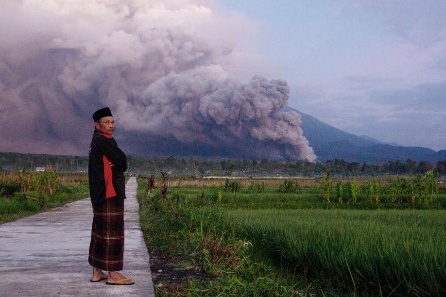 Ein Mann beobachtet den Ausbruch des Vulkans Semeru.