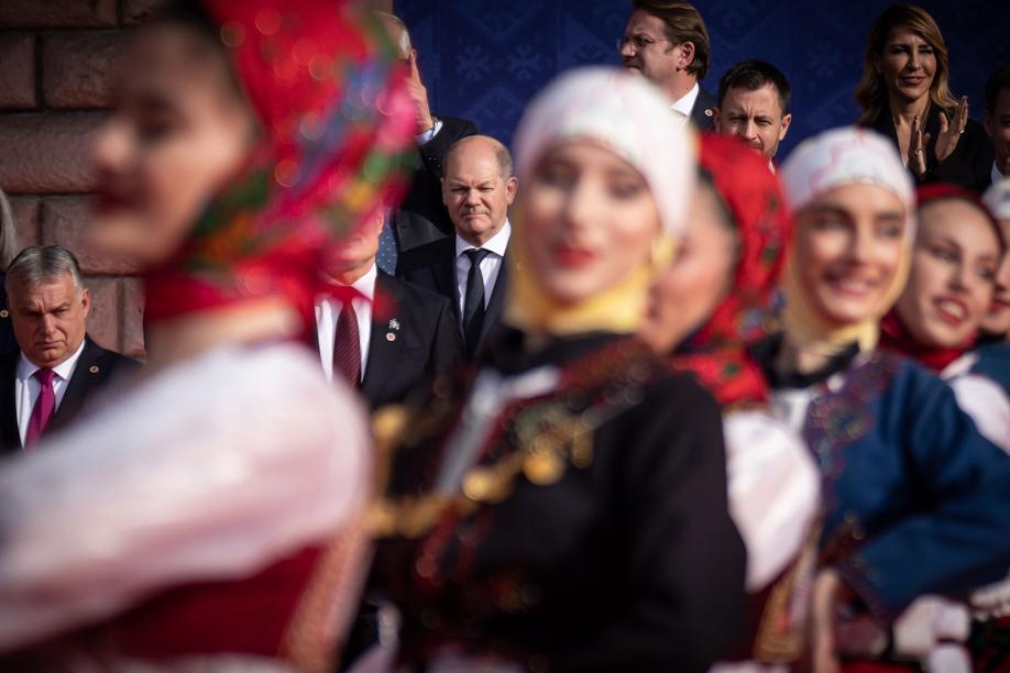 Bundeskanzler Olaf Scholz (M) beobachtet eine traditionelle Tanzvorführung beim Familienfoto beim EU-Westbalkan-Gipfel. Links ist Viktor Orban, Ministerpräsident von Ungarn, zu sehen.