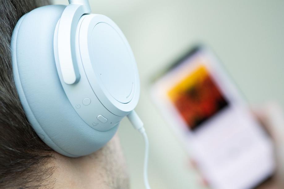 Ein junger Mann hört mit Kopfhörern Musik. Doch Kopfhörer bergen Risiken, vor allem bei Dauerbeschallung in hoher Lautstärke.
