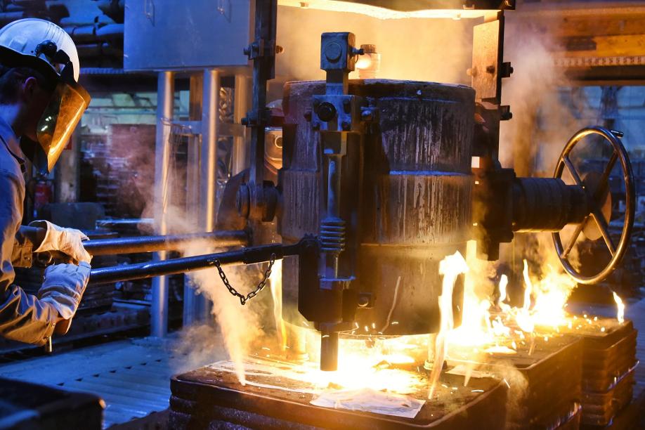 Industrieproduktion in Deutschland: Im Schmelzbetrieb einer Gießerei füllt ein Gießereimechaniker das bei etwa 1600 Grad Celsius geschmolzene Metall in Formen für Pumpenspiralgehäuse (Symbolbild).