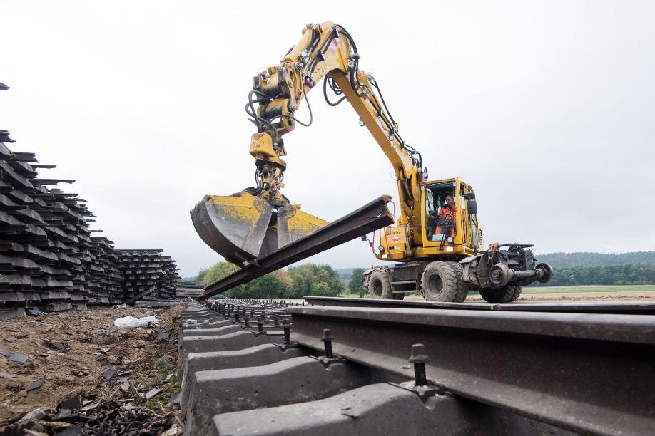 Arbeiter zerlegen mit einem Bagger alte Bahnschienen während der Sanierung einer ICE-Trasse in Niedersachsen.