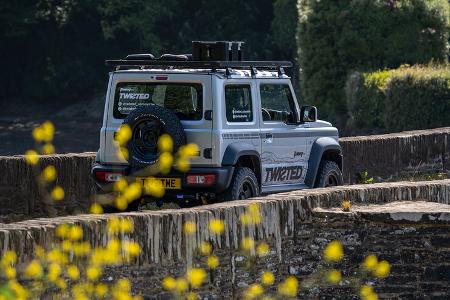Twisted Suzuki Jimny von vorn auf Steinbrücke mit gelben Blumen