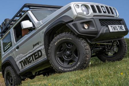 Twisted Suzuki Jimny fährt über eine Wiese mit Geländereifen.