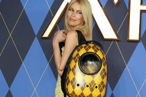 Claudia Schiffer posiert mit Katze im Rucksack auf dem roten Teppich