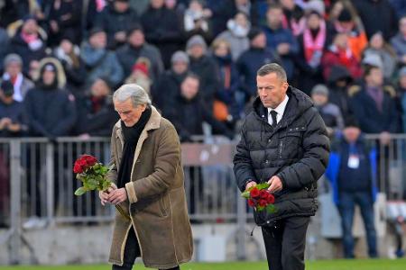 Die Weltmeister Wolfgang Overath und Lothar Matthäus legen am Mittelkreis Rosen für Franz Beckenbauer nieder.